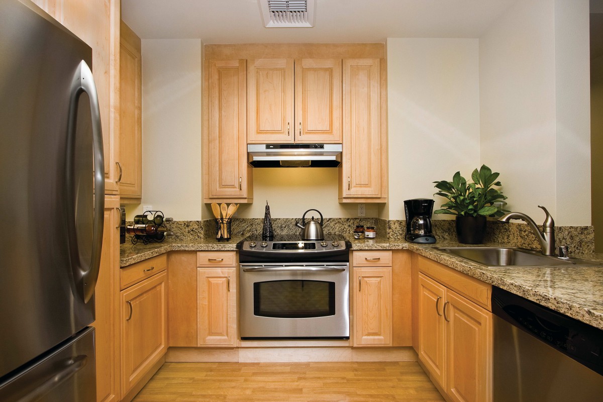 A modern kitchen with wooden cabinets and stainless steel appliances.