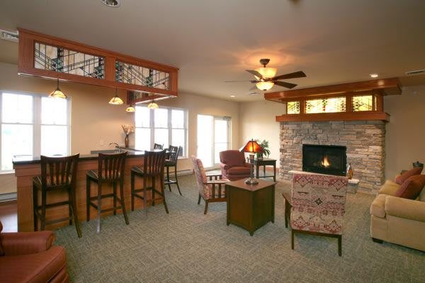 A cozy living room featuring a fireplace, bar area, and comfortable seating.