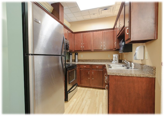 A modern kitchen with stainless steel appliances and wood cabinetry.
