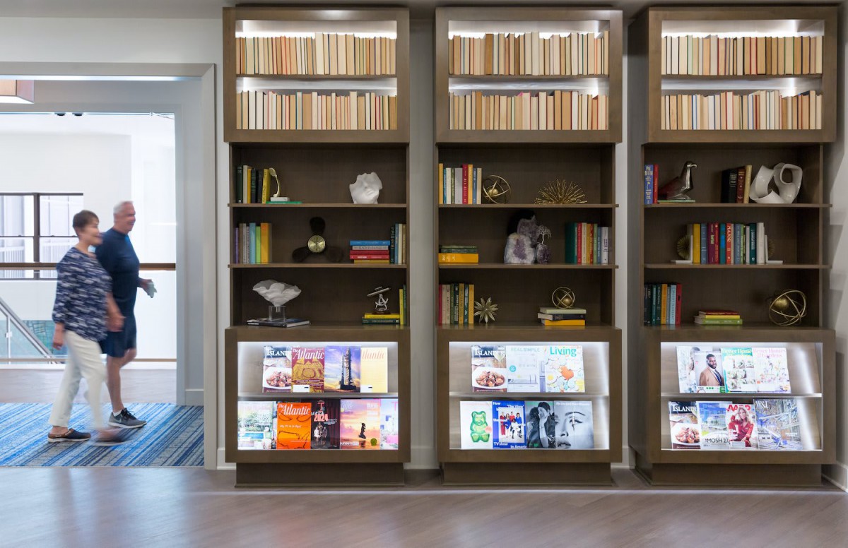A well-organized bookshelf with various books and decorative items in a stylish interior setting.