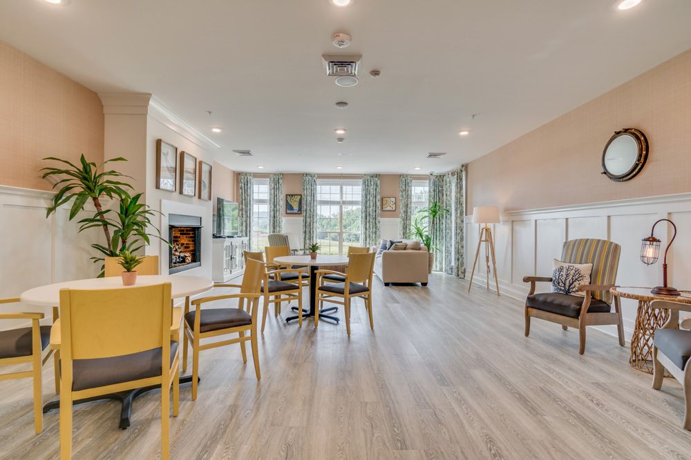 A spacious and modern living room with ample seating, large windows, and a cozy fireplace.