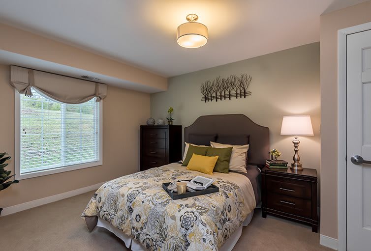 A cozy bedroom with a stylish bed and elegant decor.