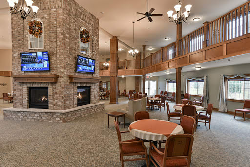 A spacious and cozy lounge area with a fireplace, multiple televisions, and comfortable seating arrangements.