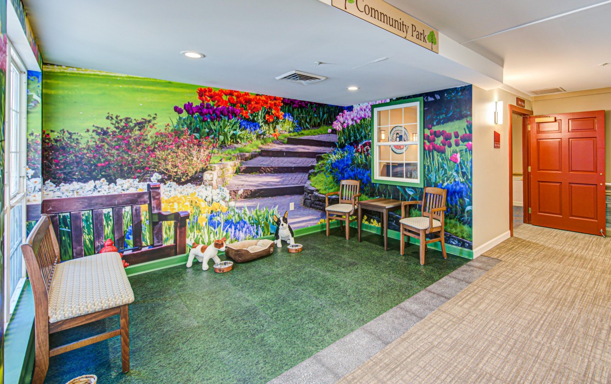 A vibrant indoor mural depicting a garden scene with seating area.