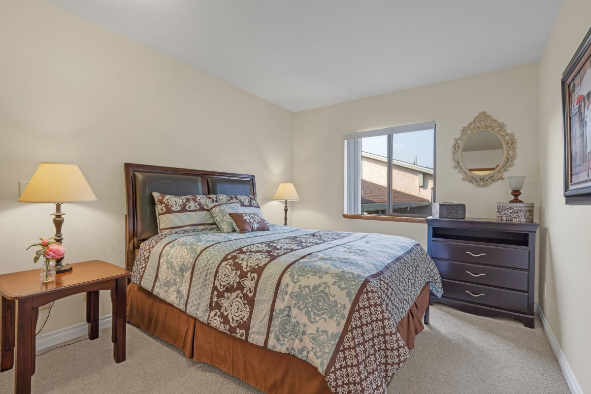 A cozy bedroom with a neatly made bed and stylish decor.