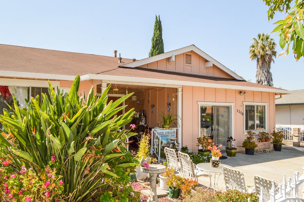 A charming house with a vibrant garden and cozy patio, perfect for enjoying a sunny day.