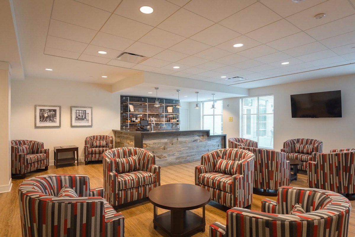 A cozy lobby with striped armchairs and a bar counter, creating a welcoming seating area.