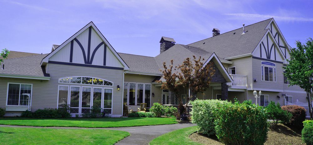 A charming suburban house surrounded by a well-maintained garden and lush greenery.