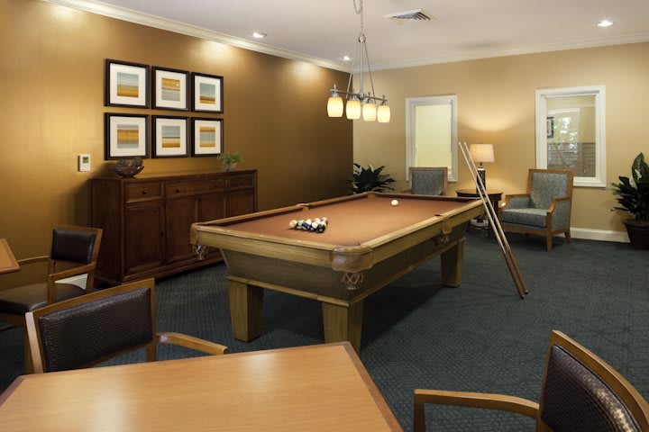A cozy billiards room featuring a pool table and comfortable seating.
