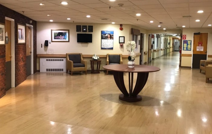 A hospital lobby with seating area and a central table.