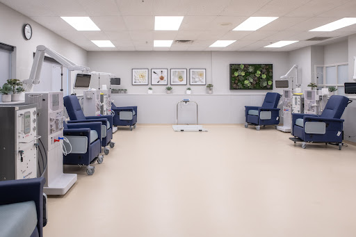 A spacious and well-lit dialysis treatment room with comfortable patient chairs.
