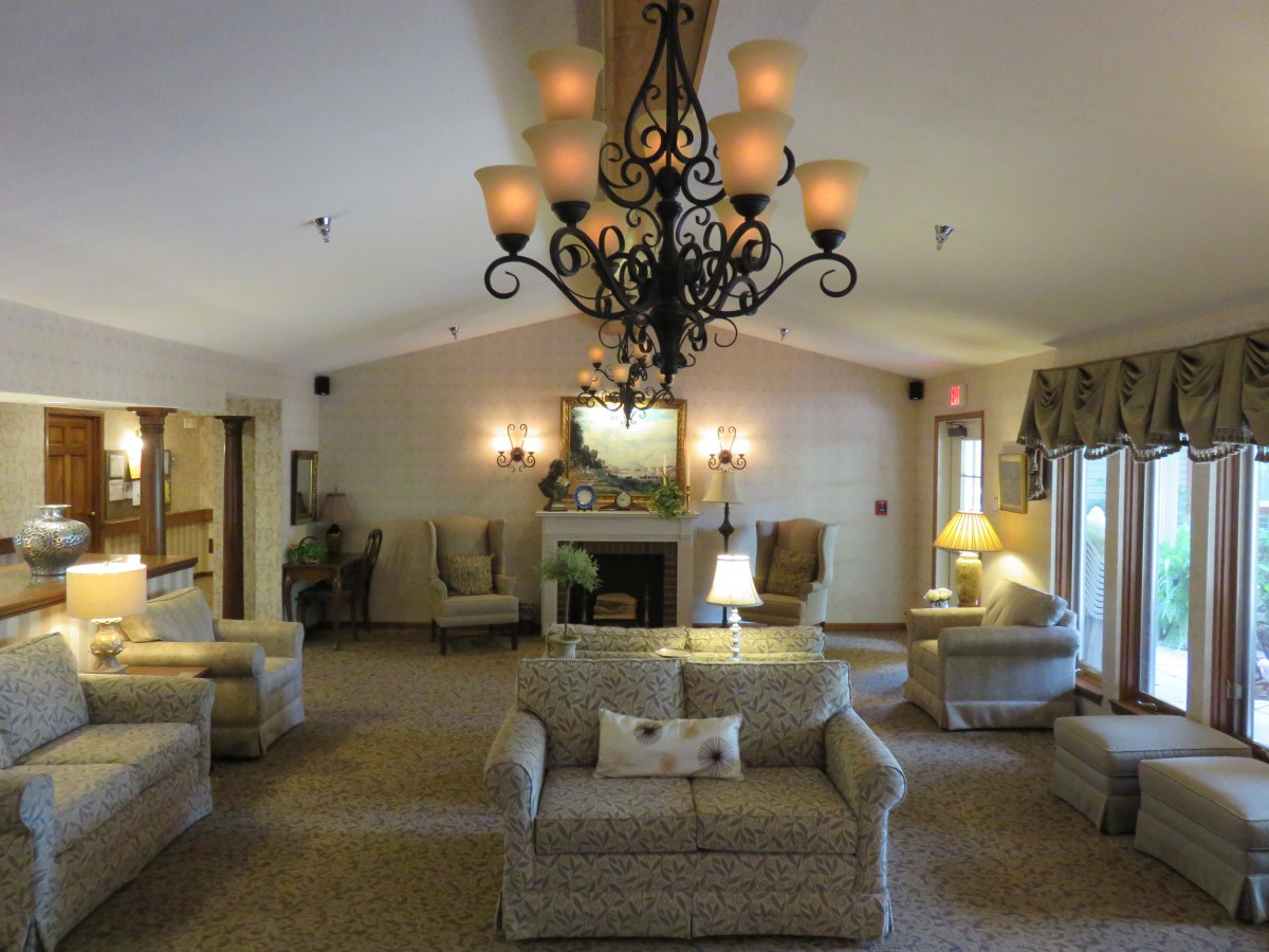 An elegantly decorated living room featuring a large chandelier, multiple sofas, and a fireplace.