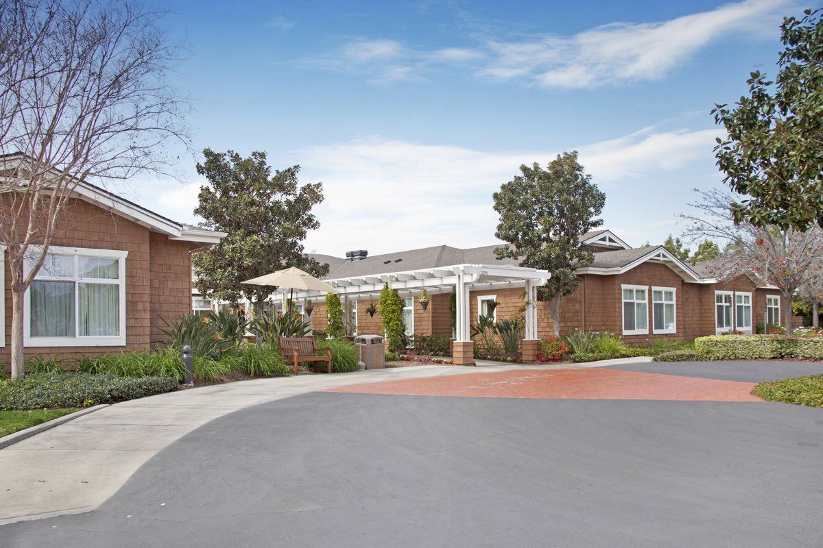 A scenic view of a brick building surrounded by greenery and a clear sky.