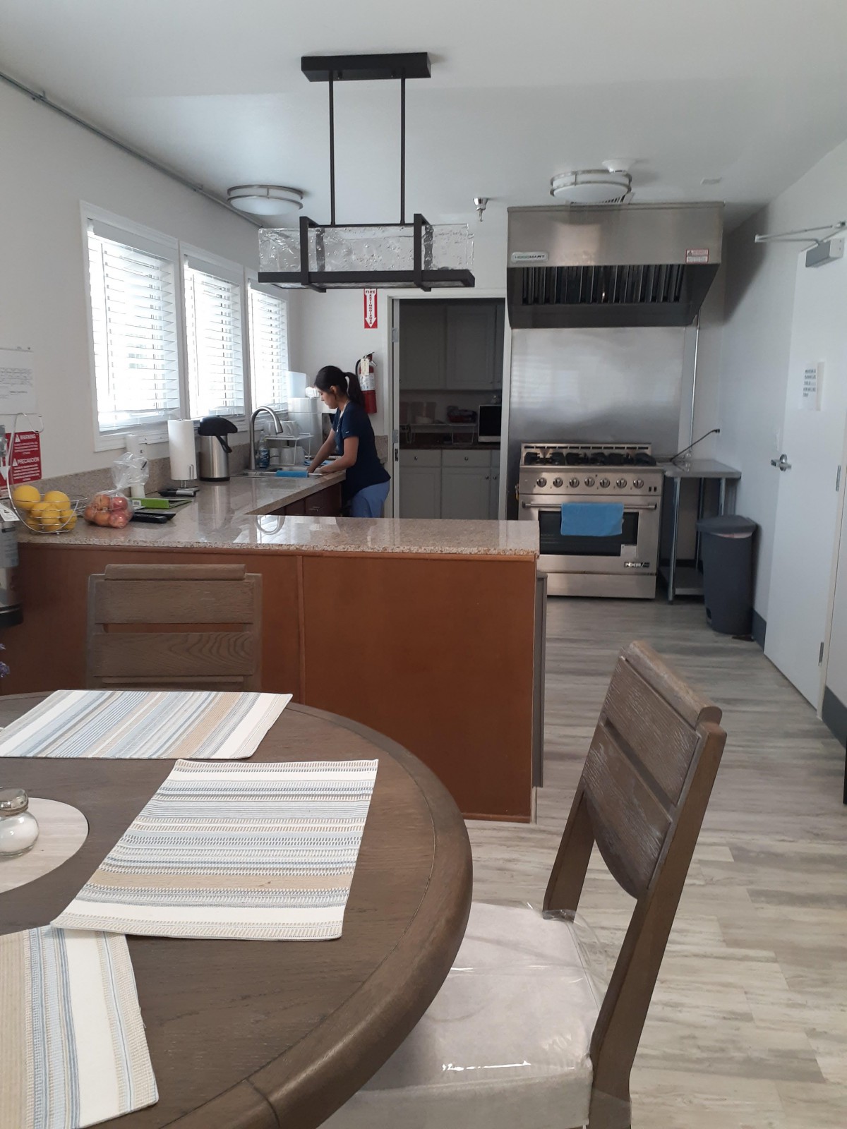A well-equipped modern kitchen with a person preparing food.