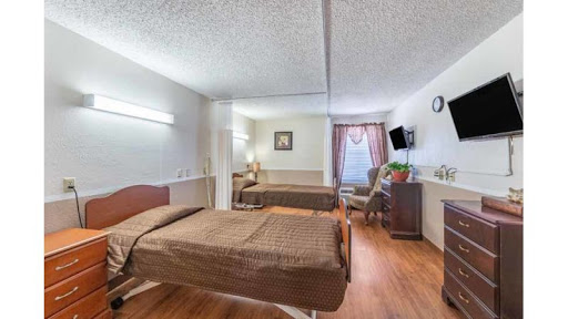 A spacious hospital room designed for patient comfort, featuring two beds and essential furnishings.