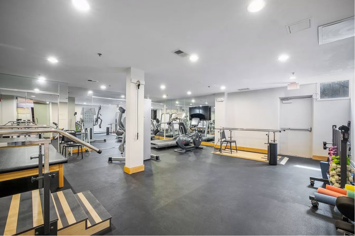A spacious gym with various workout equipment and machines.