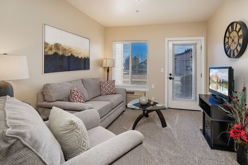A cozy and modern living room with a sofa, artwork, and ample natural light.