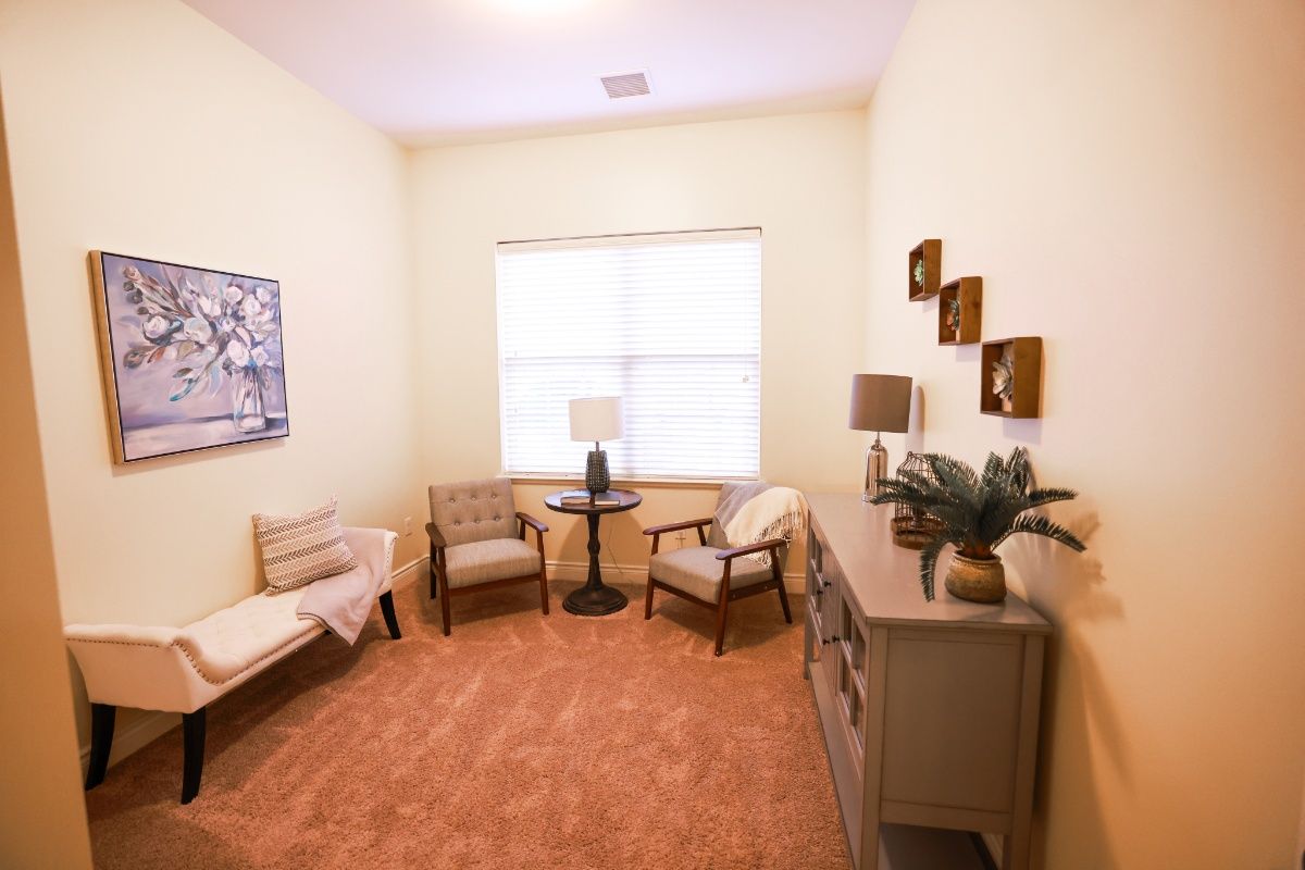 A cozy living room with comfortable seating, a side table, and decorative elements.