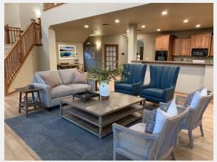 A beautifully designed living room with comfortable seating and a view of the kitchen.