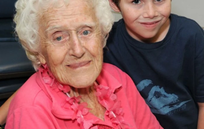 An elderly woman and a child smiling warmly together.
