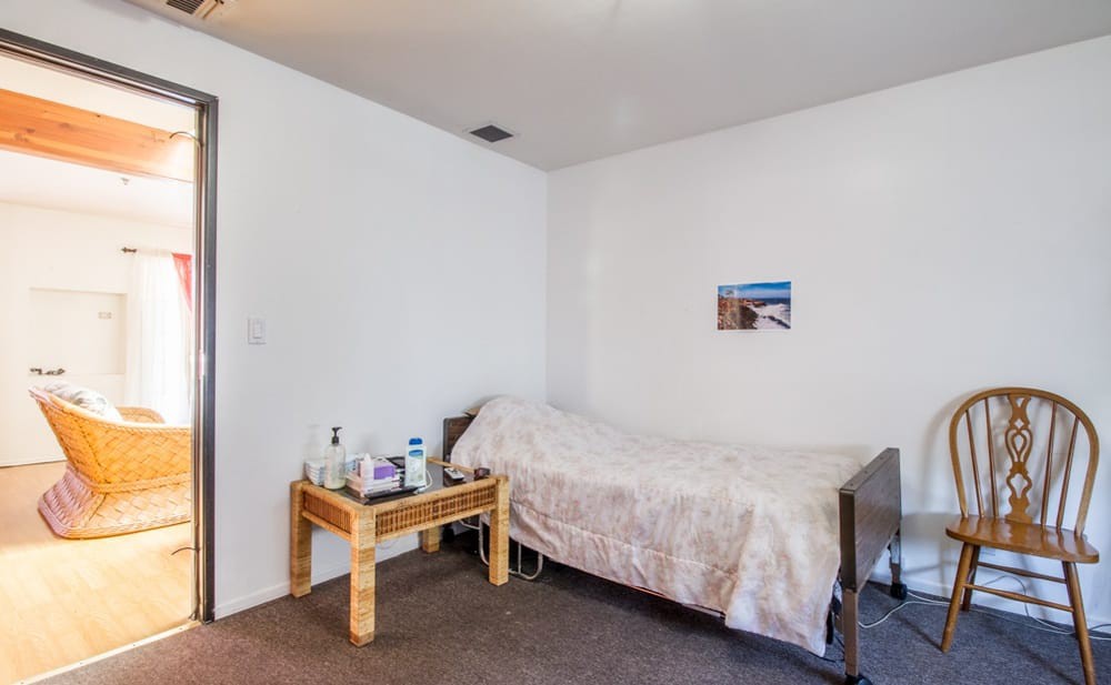 A minimalist bedroom with a single bed and a small nightstand.