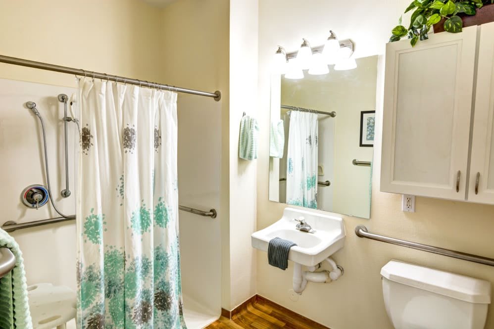 A bright and clean bathroom with a shower curtain, sink, and mirror.