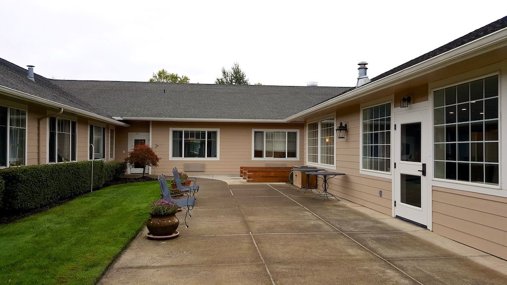A spacious patio area with outdoor furniture in the backyard of a residential house.