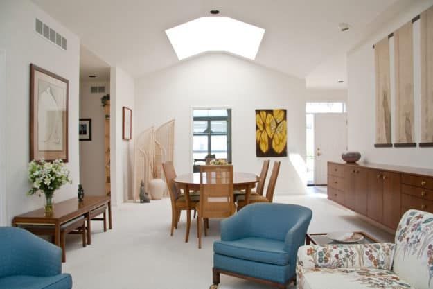 A bright and modern dining area with a skylight, featuring minimalist decor and contemporary furniture.