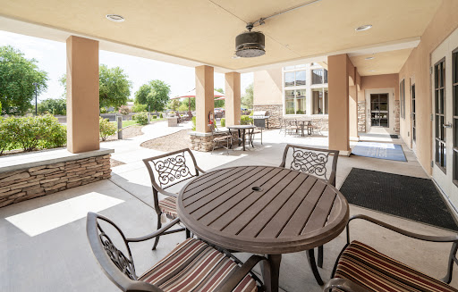 A cozy outdoor patio area with a round table and chairs, perfect for gatherings and enjoying the sunshine.