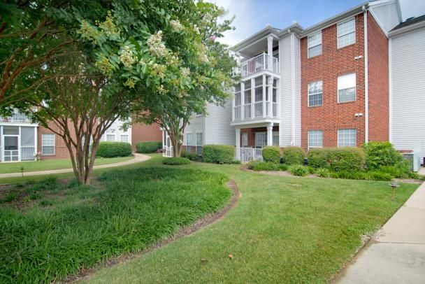 A well-maintained apartment building with a brick facade and lush landscaping.