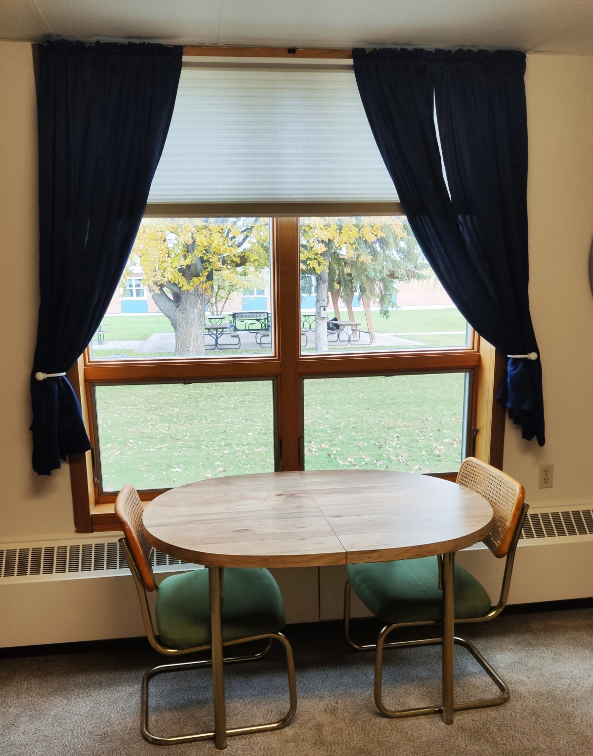 A cozy table setup by a window with dark curtains.