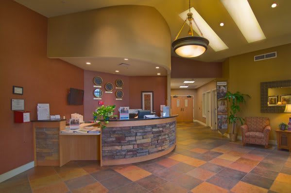 A modern reception desk in a warmly decorated office lobby.