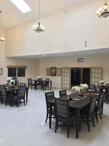 A spacious dining area featuring elegant furniture and decorative flowers.