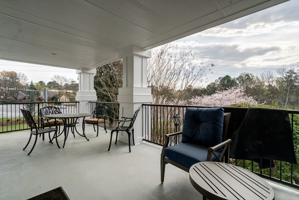 A peaceful porch with multiple seating areas and a scenic view.