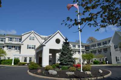 A residential building with a driveway and American flag in front.