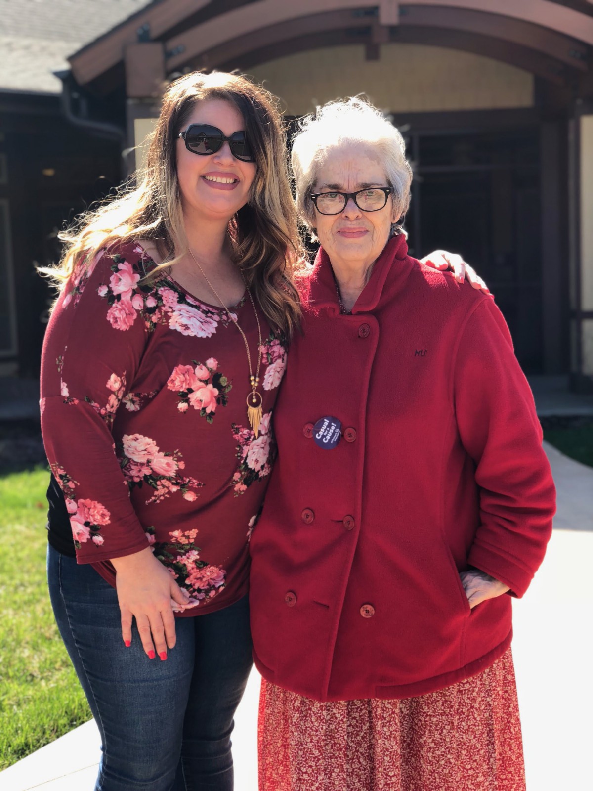 Two women posing together outside on a sunny day.