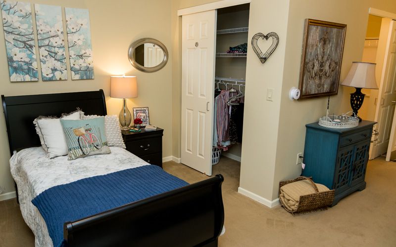 A cozy bedroom with an open closet, stylish decor, and a neatly made bed.