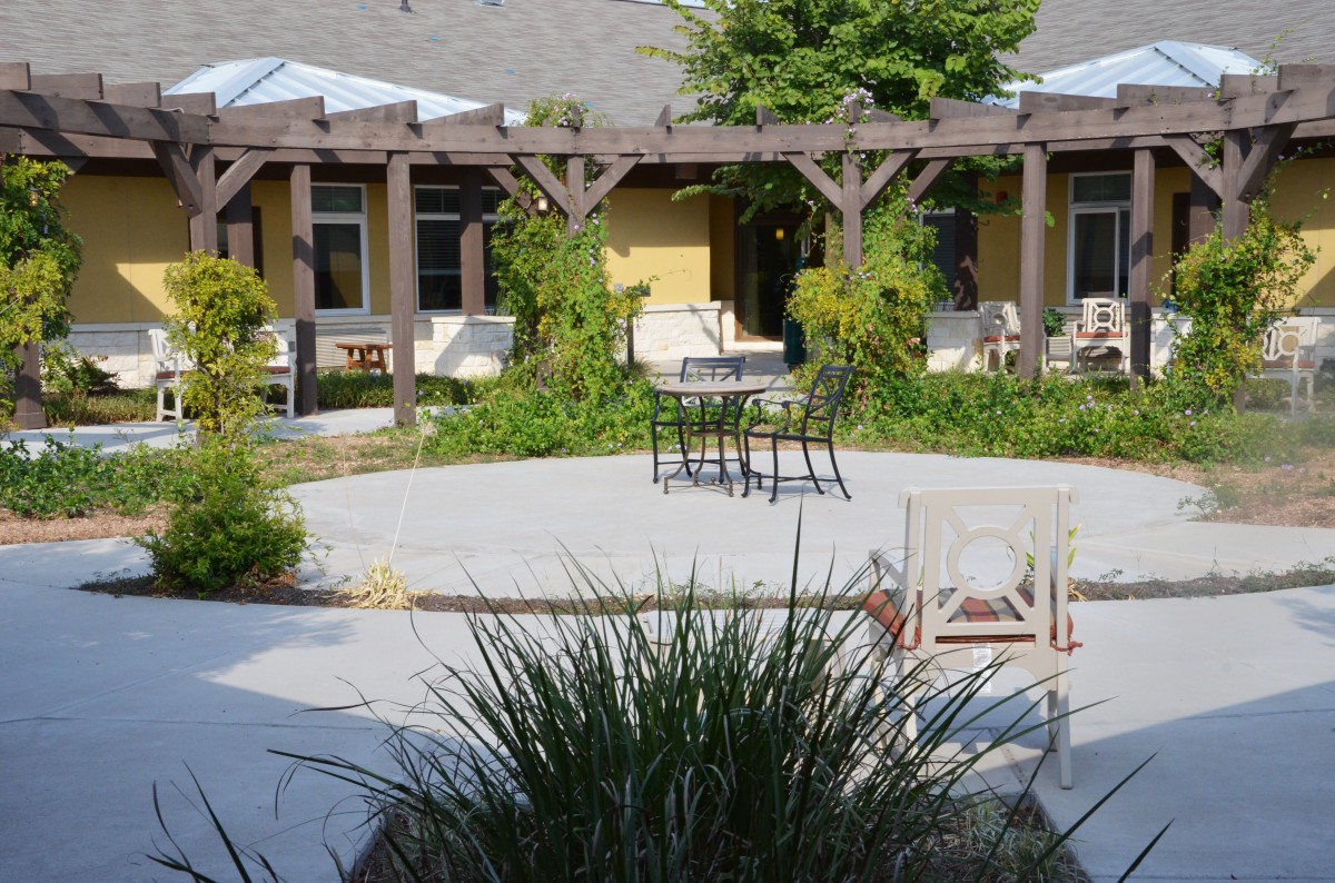 Cozy outdoor patio area with seating and lush greenery.
