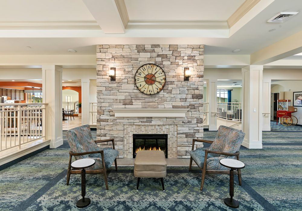 A cozy seating area with a brick fireplace and decorative clock in a modern living room.