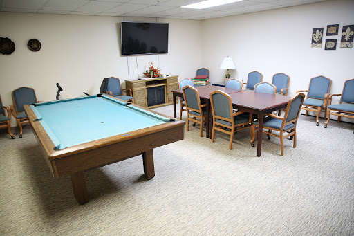 A spacious game room featuring a pool table and a cozy dining area, complete with a television.
