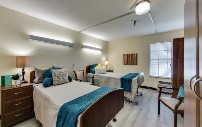 A modern bedroom with two neatly made beds, featuring stylish decor and soft lighting.
