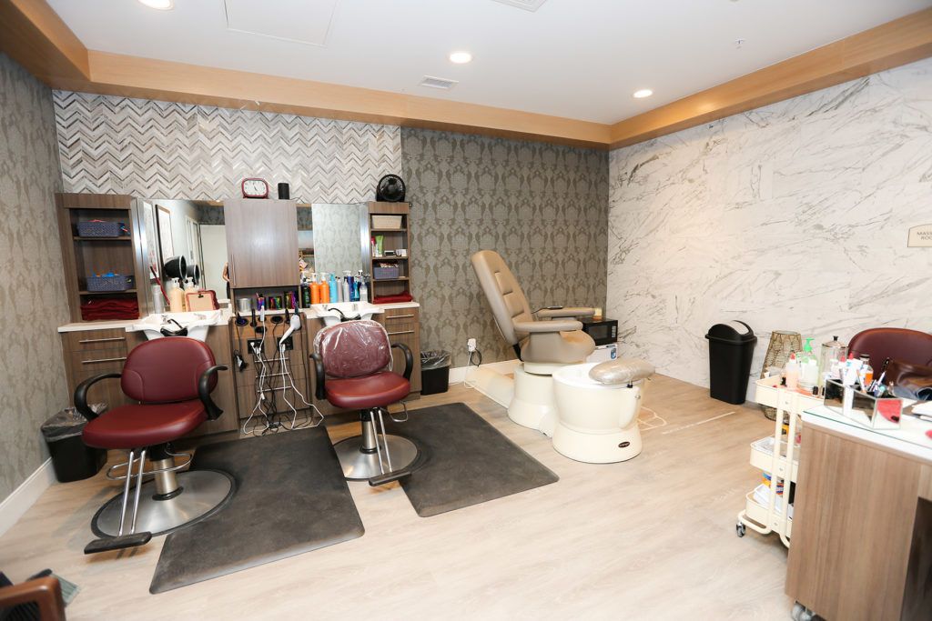 A cozy beauty salon featuring hair styling stations and a pedicure chair.