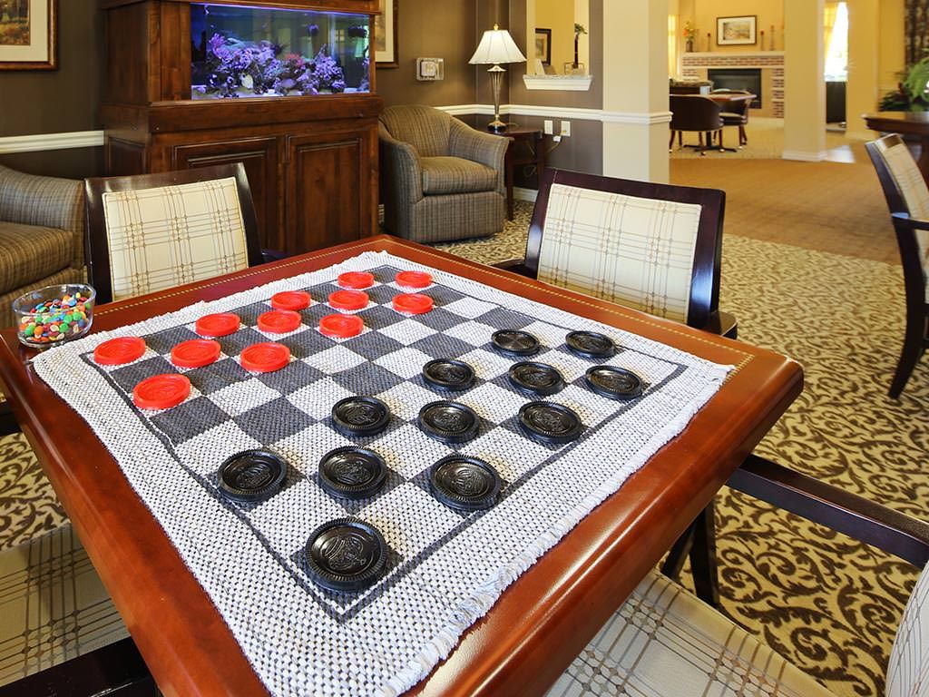 A checkers game set up on a table in a cozy living room setting.