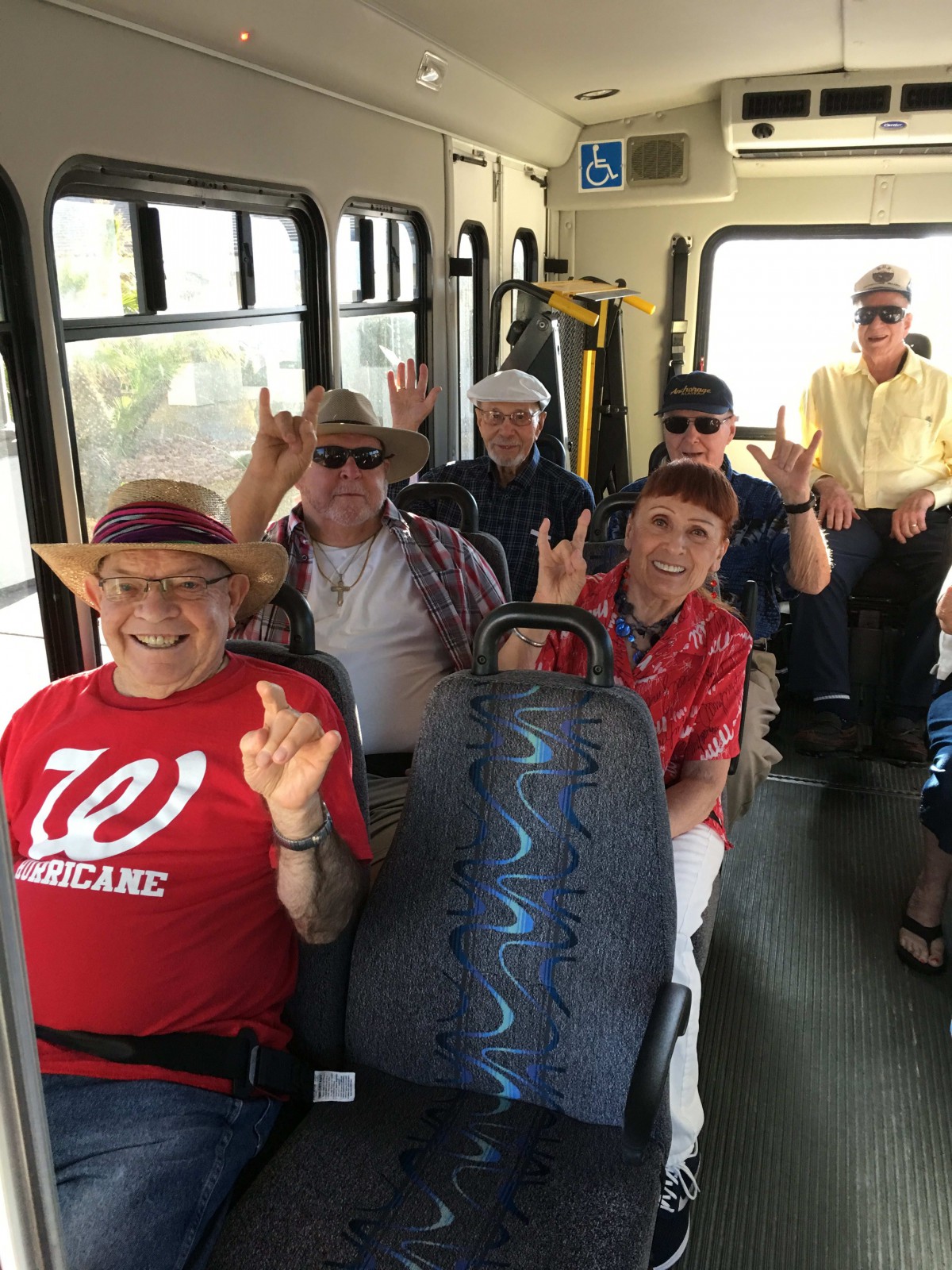 A cheerful group of seniors enjoying a bus ride.