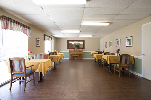 A spacious dining room featuring tables with yellow tablecloths, designed for casual dining.