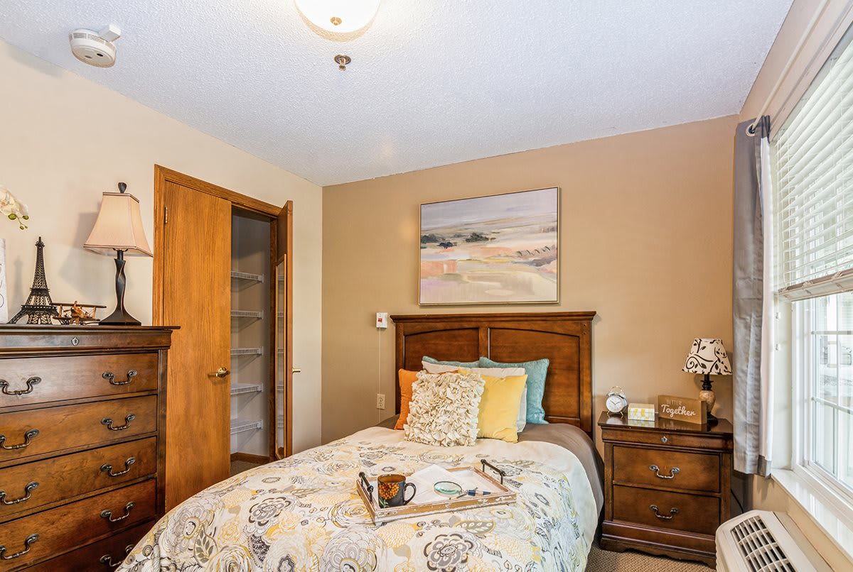 A cozy bedroom with wooden furniture and decorative bedding.