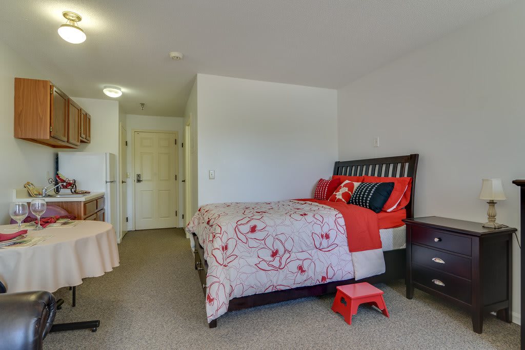 A cozy and minimalist bedroom featuring a bed with floral bedding.