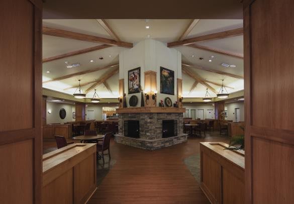 Cozy restaurant interior with a central fireplace and wooden beams.