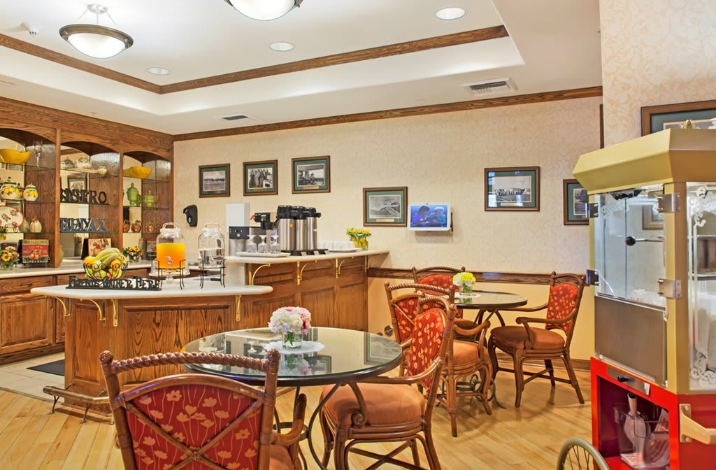 A cozy hotel breakfast area featuring a coffee station and seating with elegant decor.