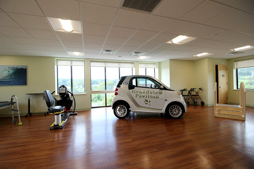 An innovative office space featuring a smart car parked indoors, showcasing modern design and ample natural light.